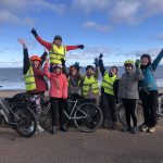 Bridgend Farmhouse Community led ride. Image shows a group of people who have been on a cycle ride to Portobello, standing by the sea wall with their bikes