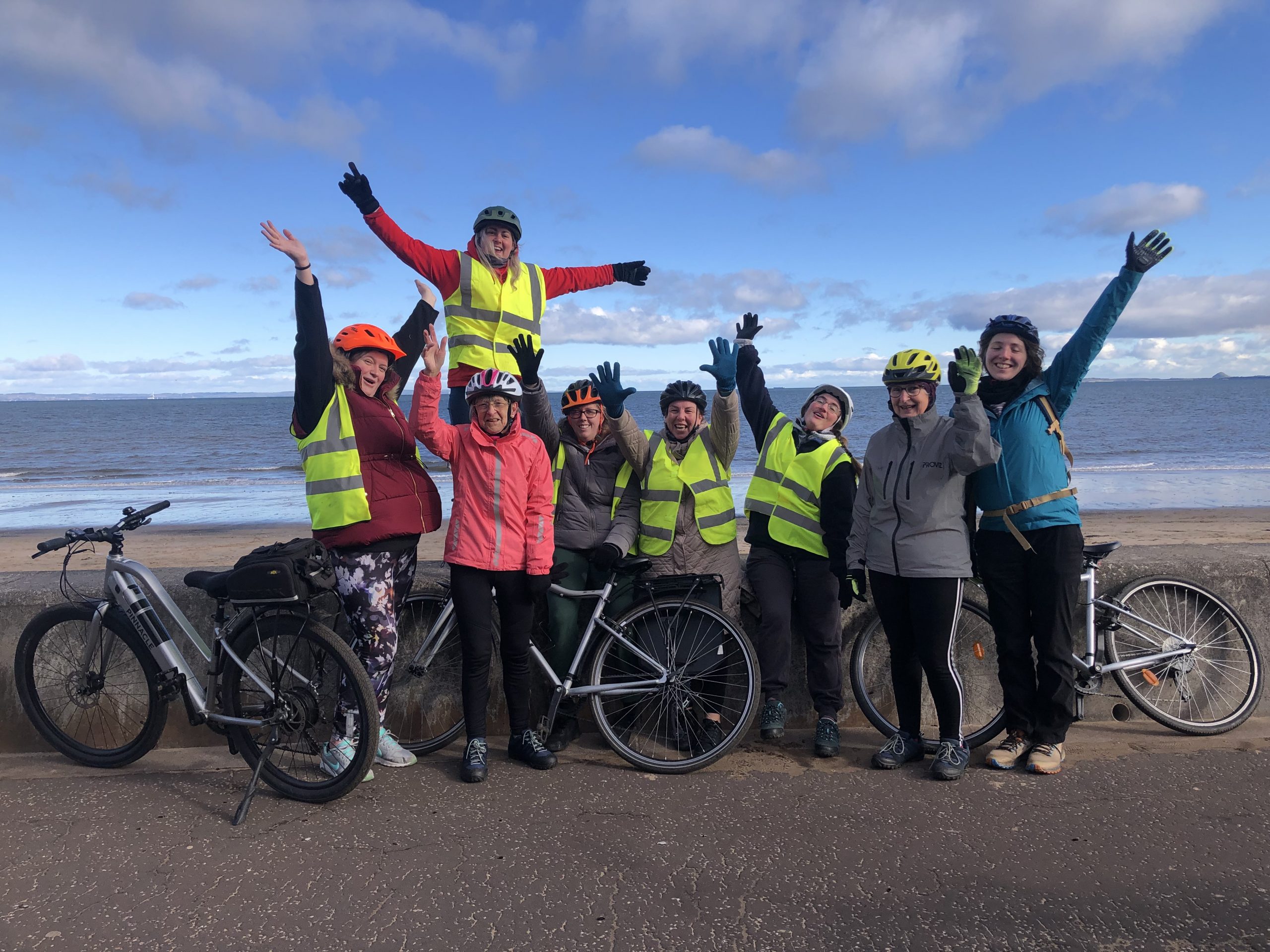 Bridgend Farmhouse Community led ride. Image shows a group of people who have been on a cycle ride to Portobello, standing by the sea wall with their bikes