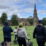A wee pedal: Edinburgh Cycle Tours. The image show a group of people on a cycle tour, standing looking at Brunsfield Links