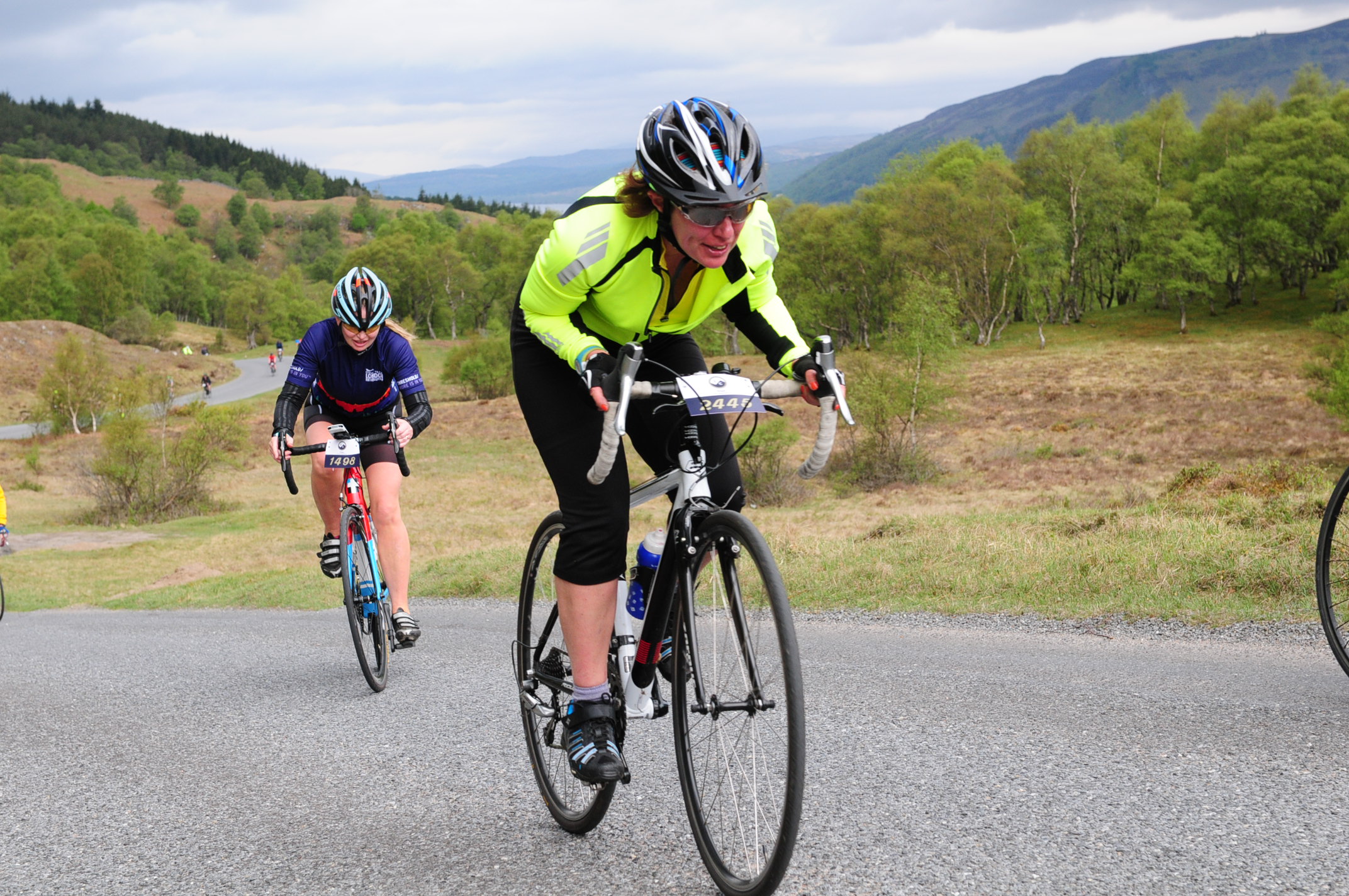 Picture shows two cyclists riding up hill